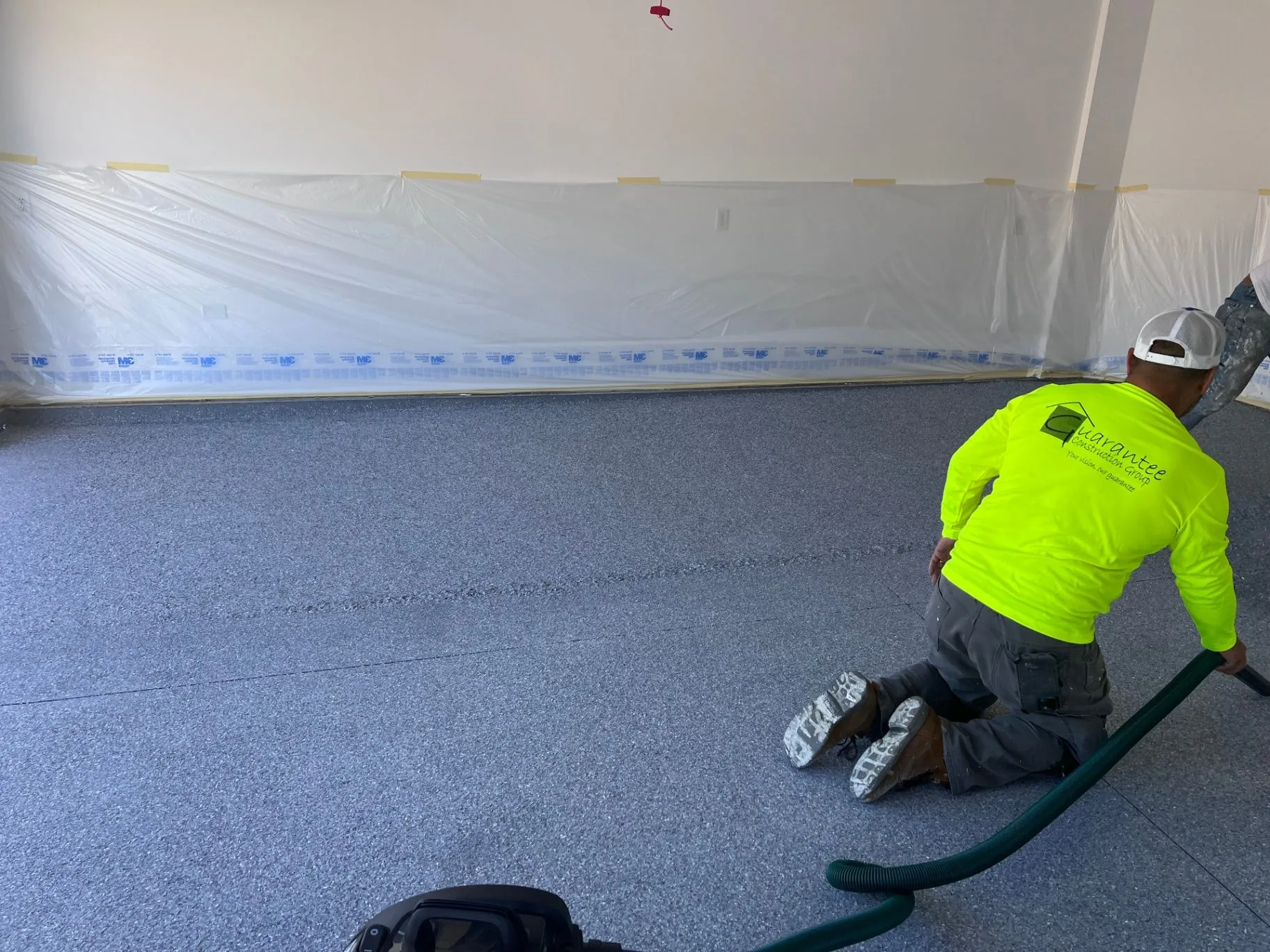 Flake epoxy floor coating installation in Blaine, MN, with walls covered for protection