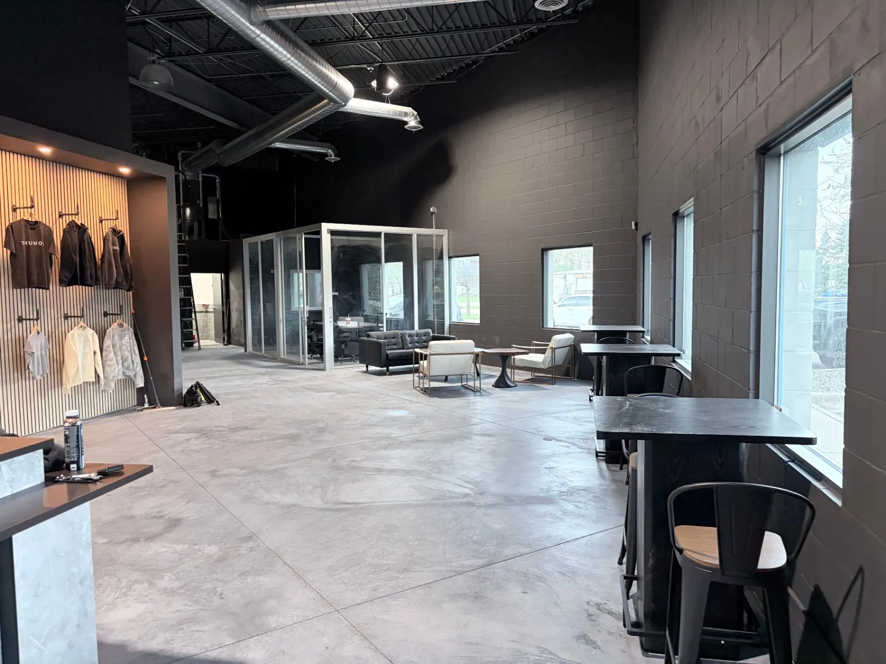 Refinished concrete floor in service at a commercial gym in Blaine, MN, beside the glass-walled office