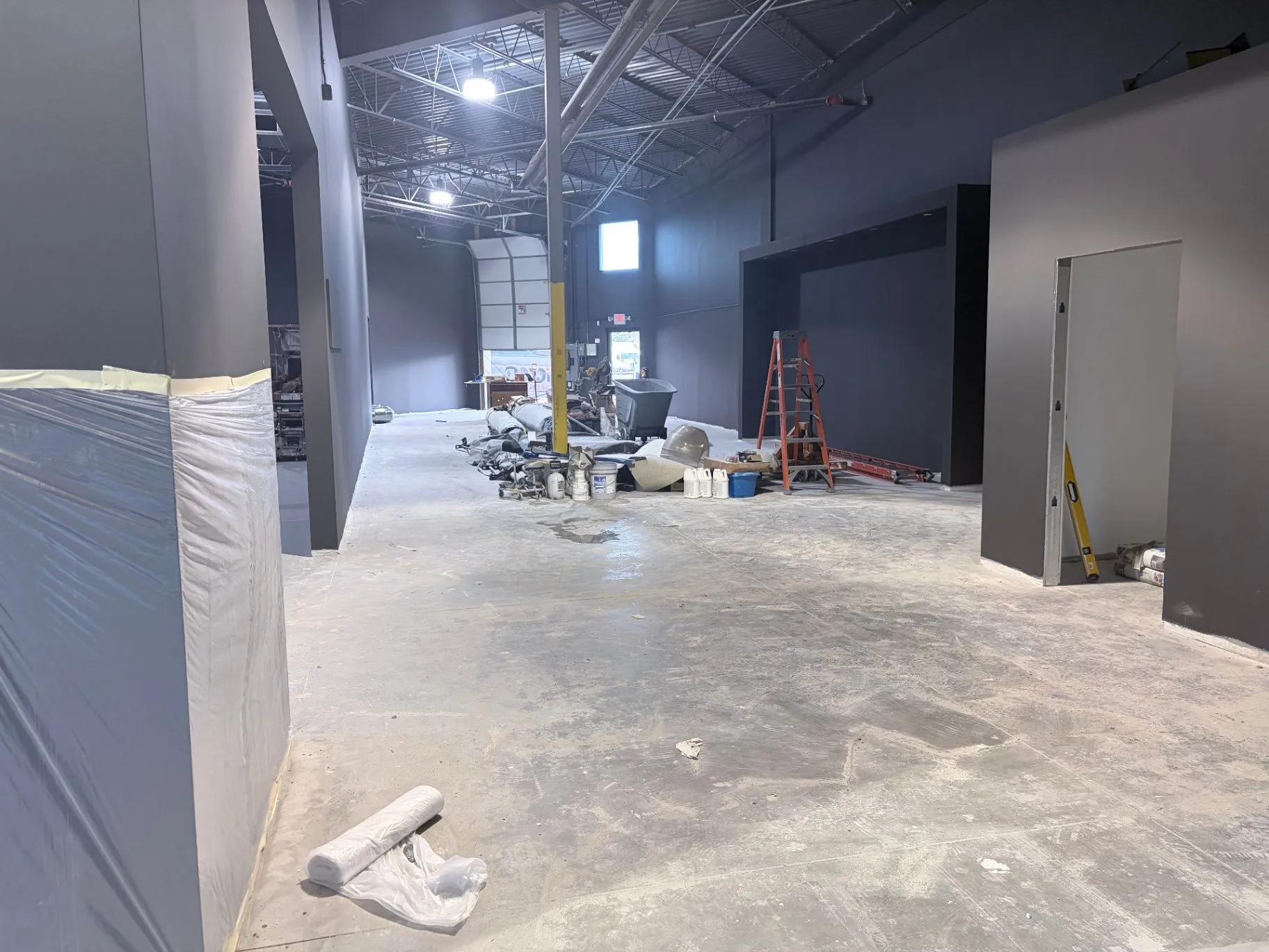 Commercial gym concrete floor preparation with grinding equipment staged in Blaine, MN