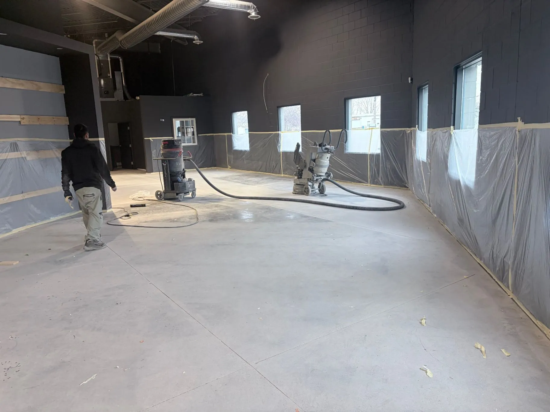Concrete surface grinding and dust-control equipment in a commercial gym in Blaine, MN