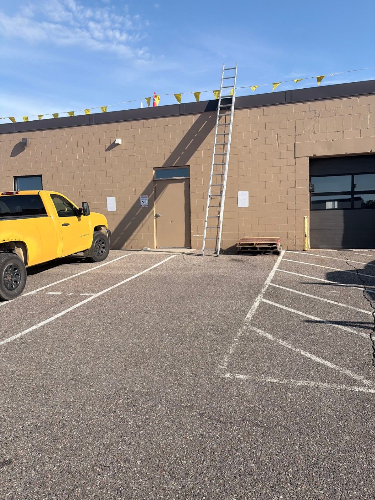 Exterior painting prep on the block exterior of the Brightview Building in Plymouth, MN, with ladders set against the wall