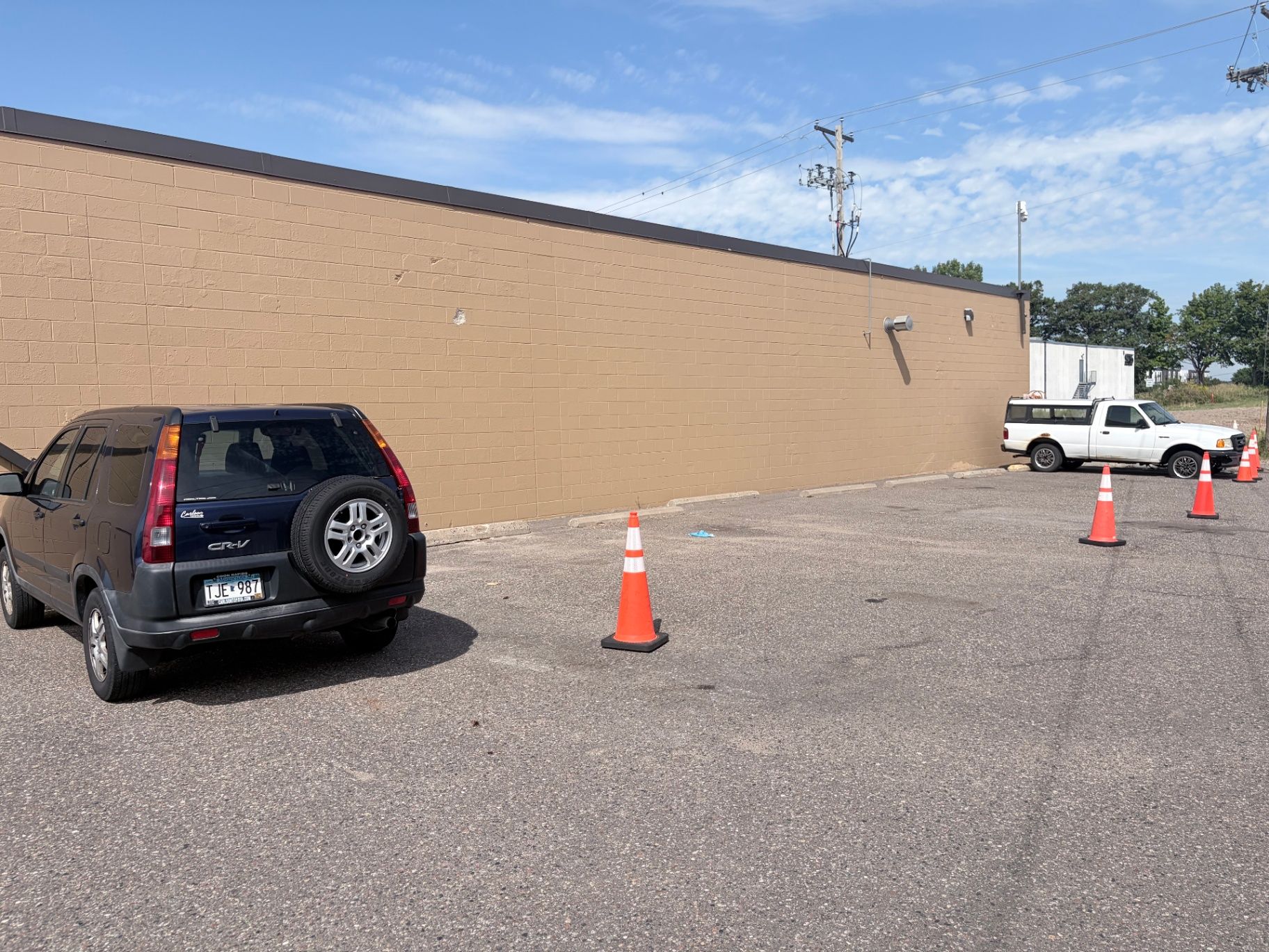 Painted commercial block wall of the Brightview Building in Plymouth, MN, with the parking area coned off during exterior painting