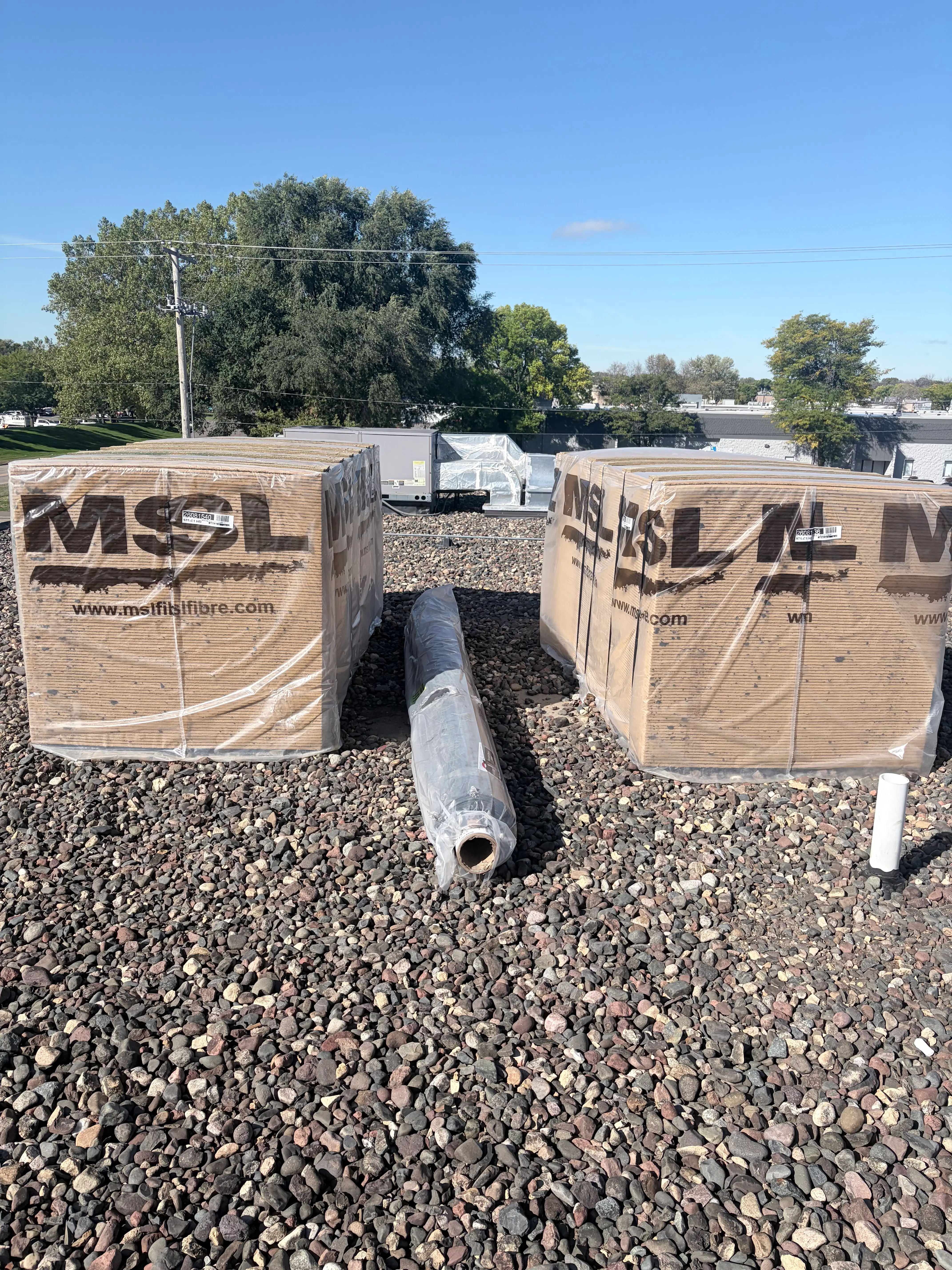 EPDM roofing materials staged on a commercial flat roof during replacement in Plymouth, MN