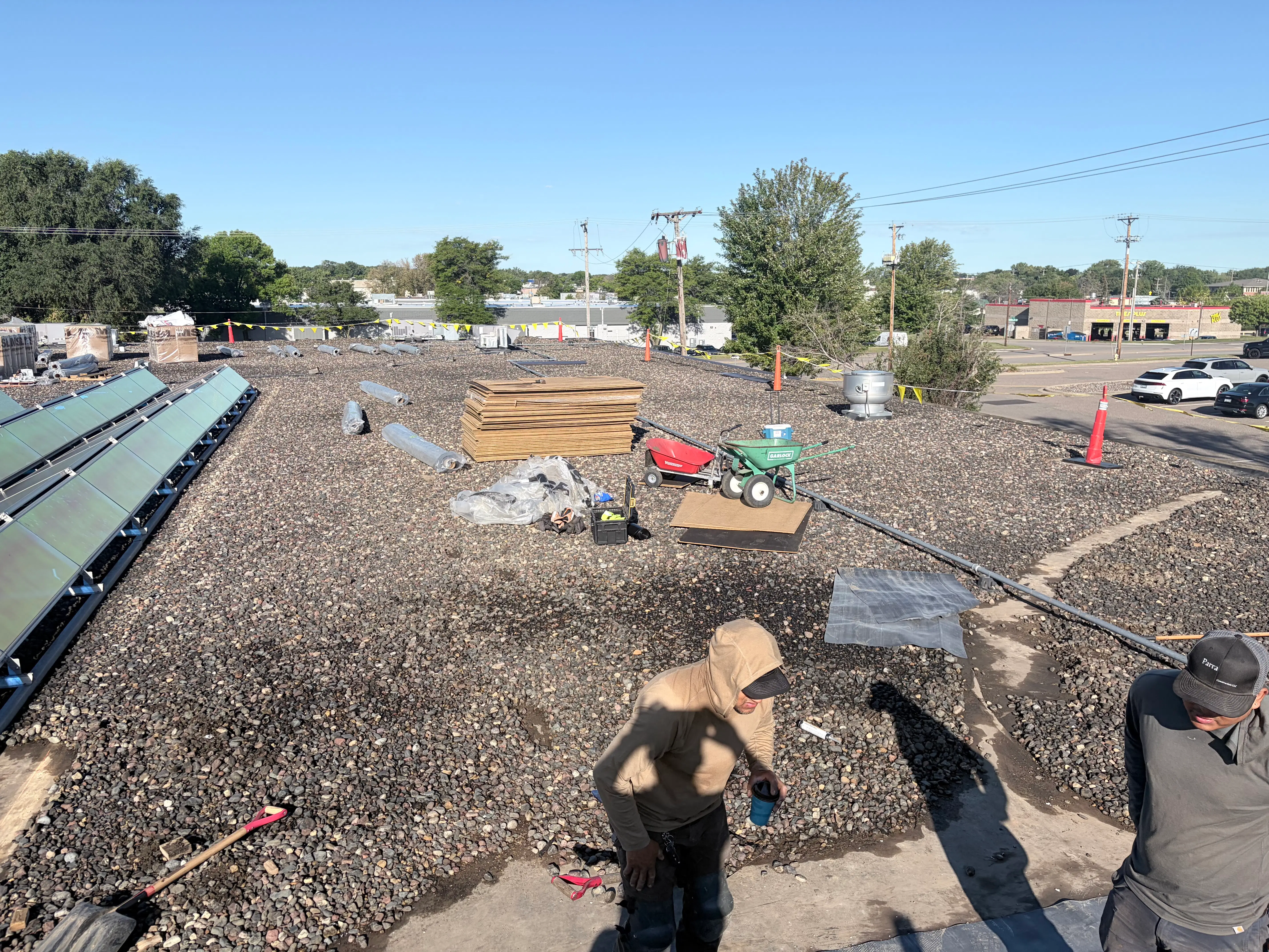 Roofing crew and materials on a commercial flat roof during full membrane replacement in Plymouth, MN