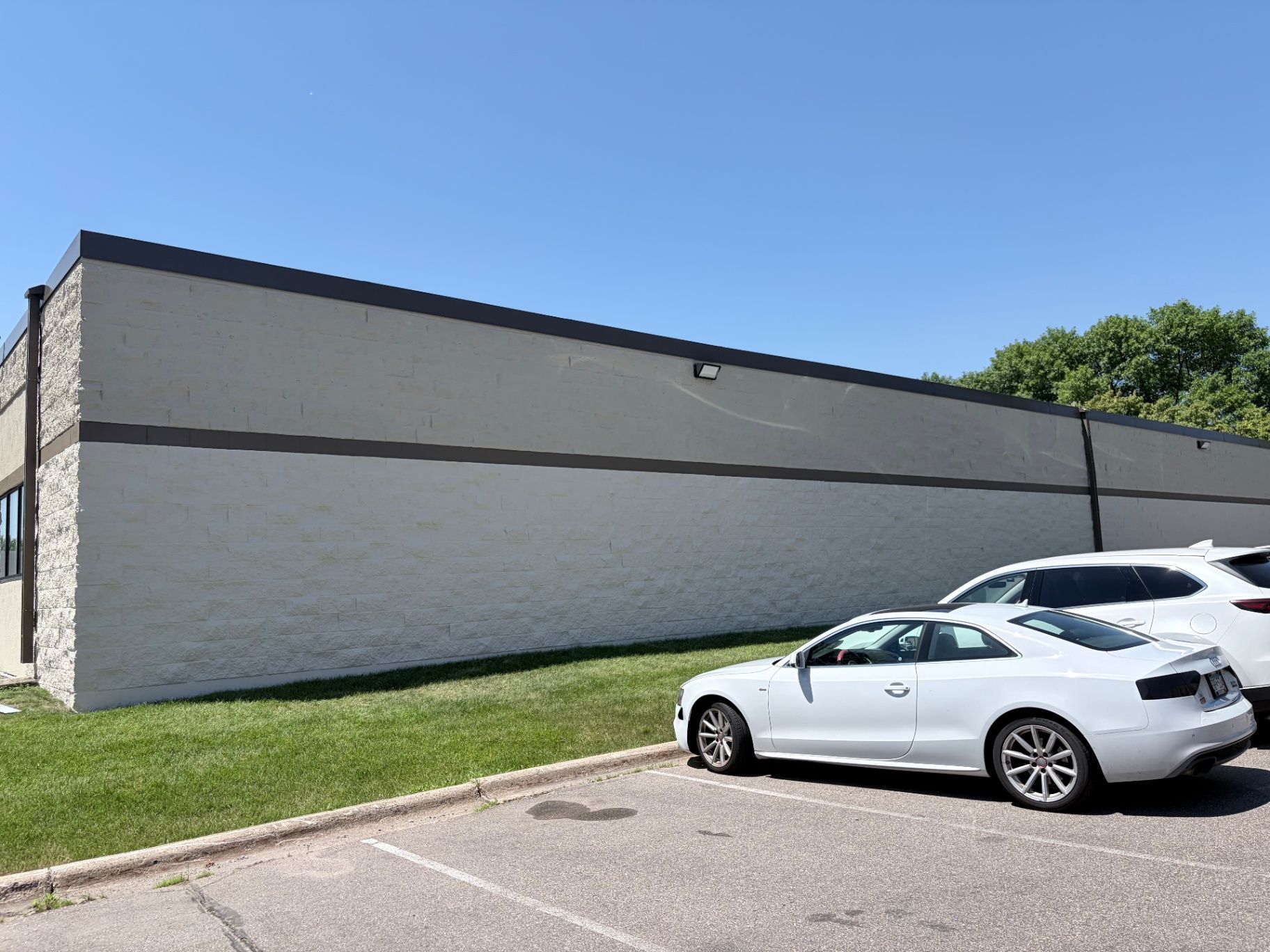 Completed white exterior wall with a dark accent band on a commercial office building in Eagan, MN