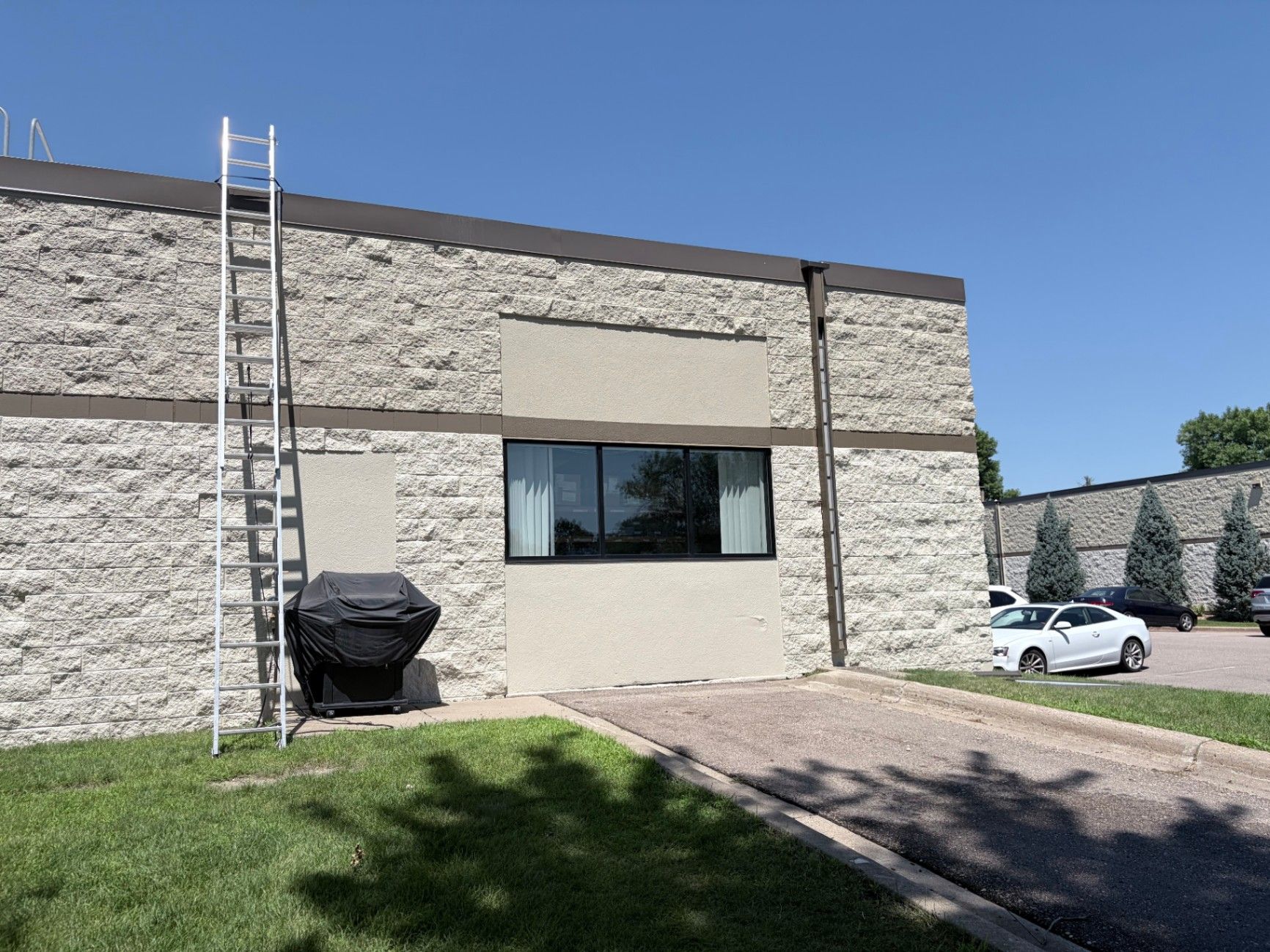 Ladder set against the exterior wall during prep work on a commercial block building in Eagan, MN