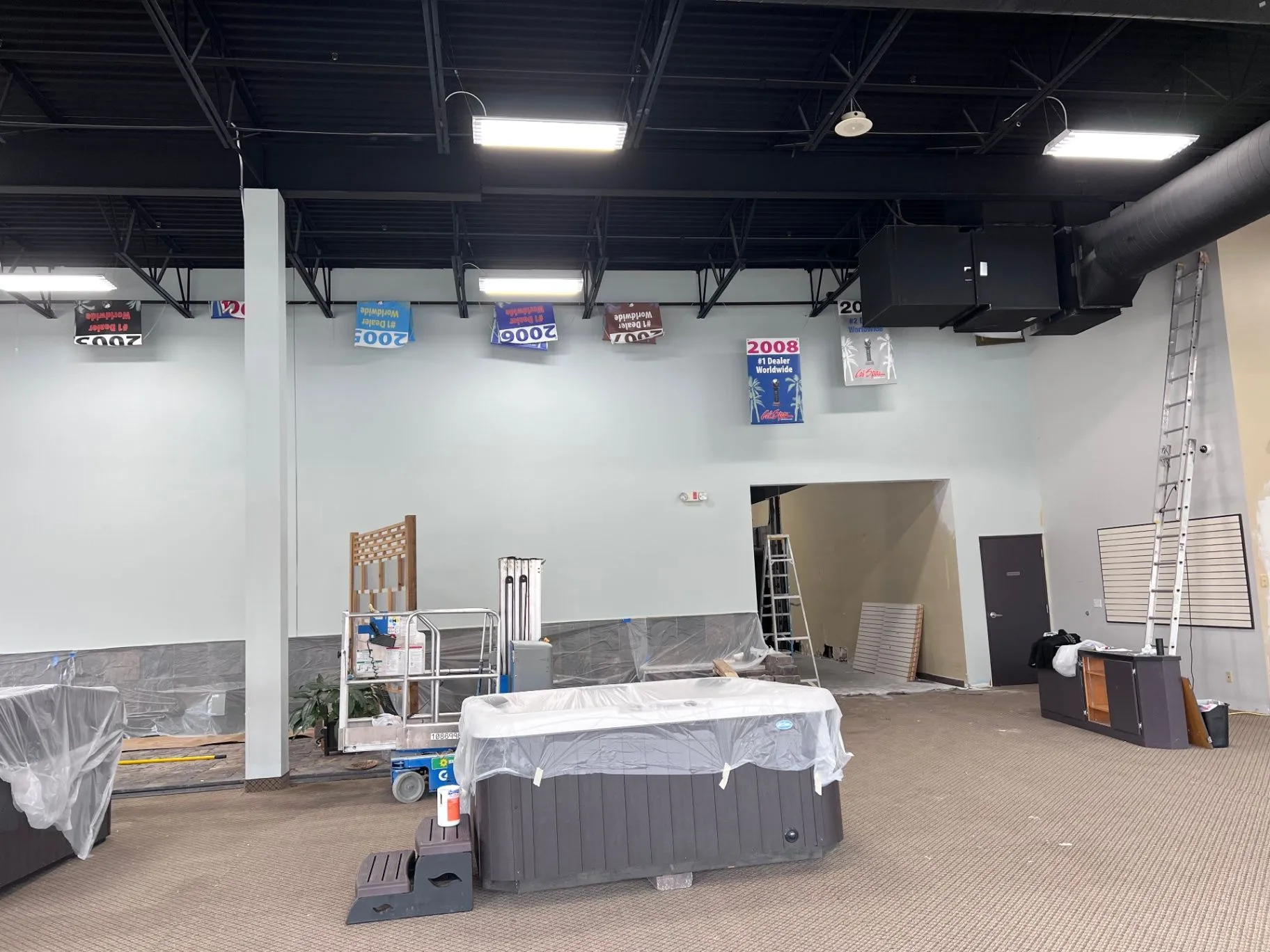 Painter on lift completing high wall work in a Plymouth, MN showroom